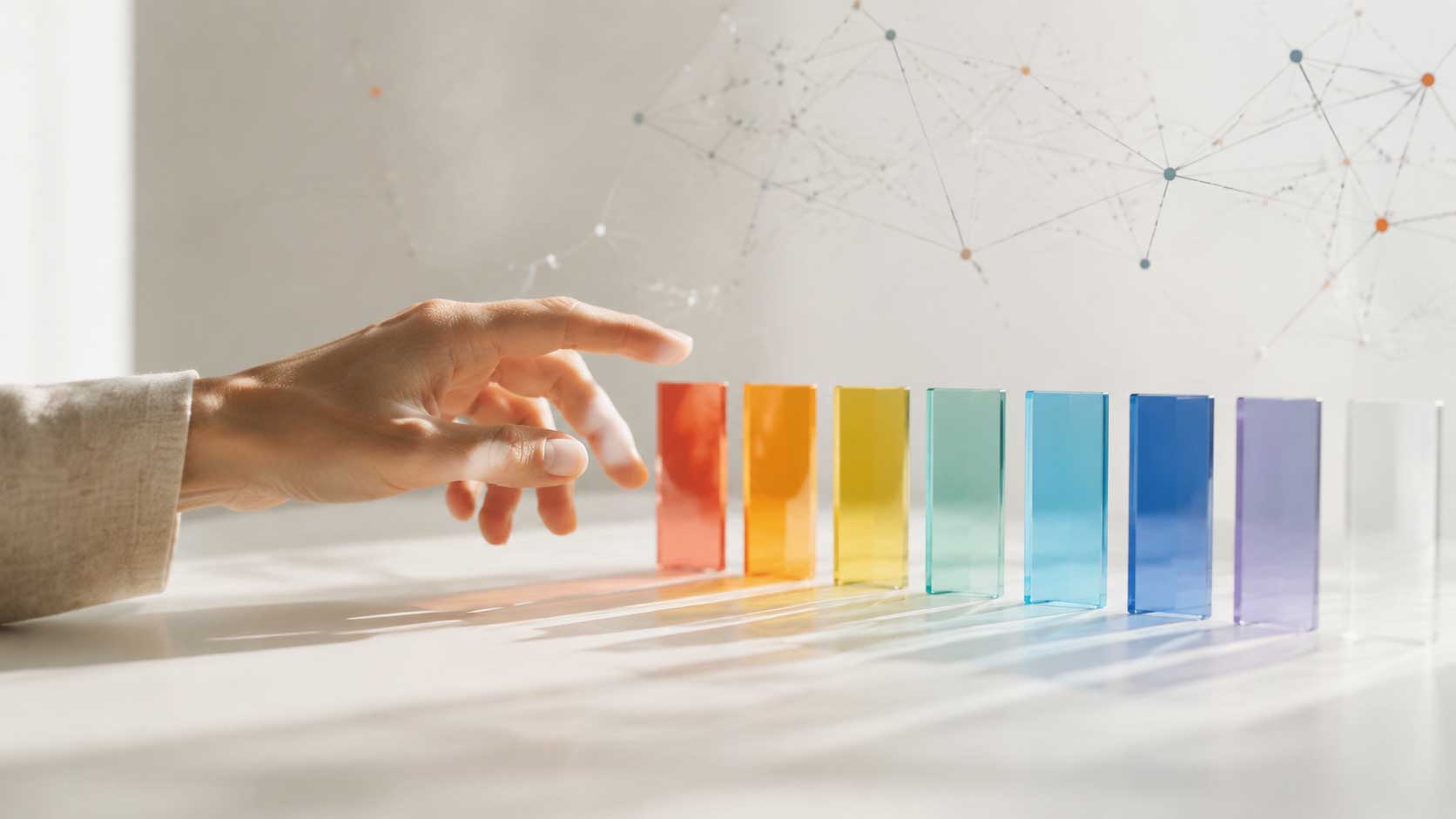 Eine Hand wählt zwischen farbigen Glasflächen vor einem feinen digitalen Netzwerk