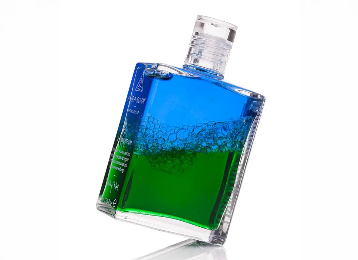 Eine verschüttelte Aura-Soma Flasche mit den Farben grün und blau Eine verschüttelte Aura-Soma Flasche mit den Farben grün und blau