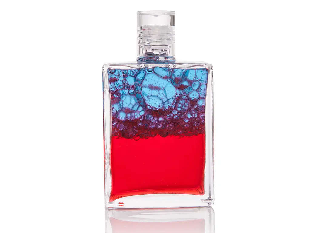 Verschüttelte Aura-Soma Flasche mit der Nr. 117 in den Farben Rot und Blau mit schönen Blasen die durch die unterschiedlichen Farben entstehen.
