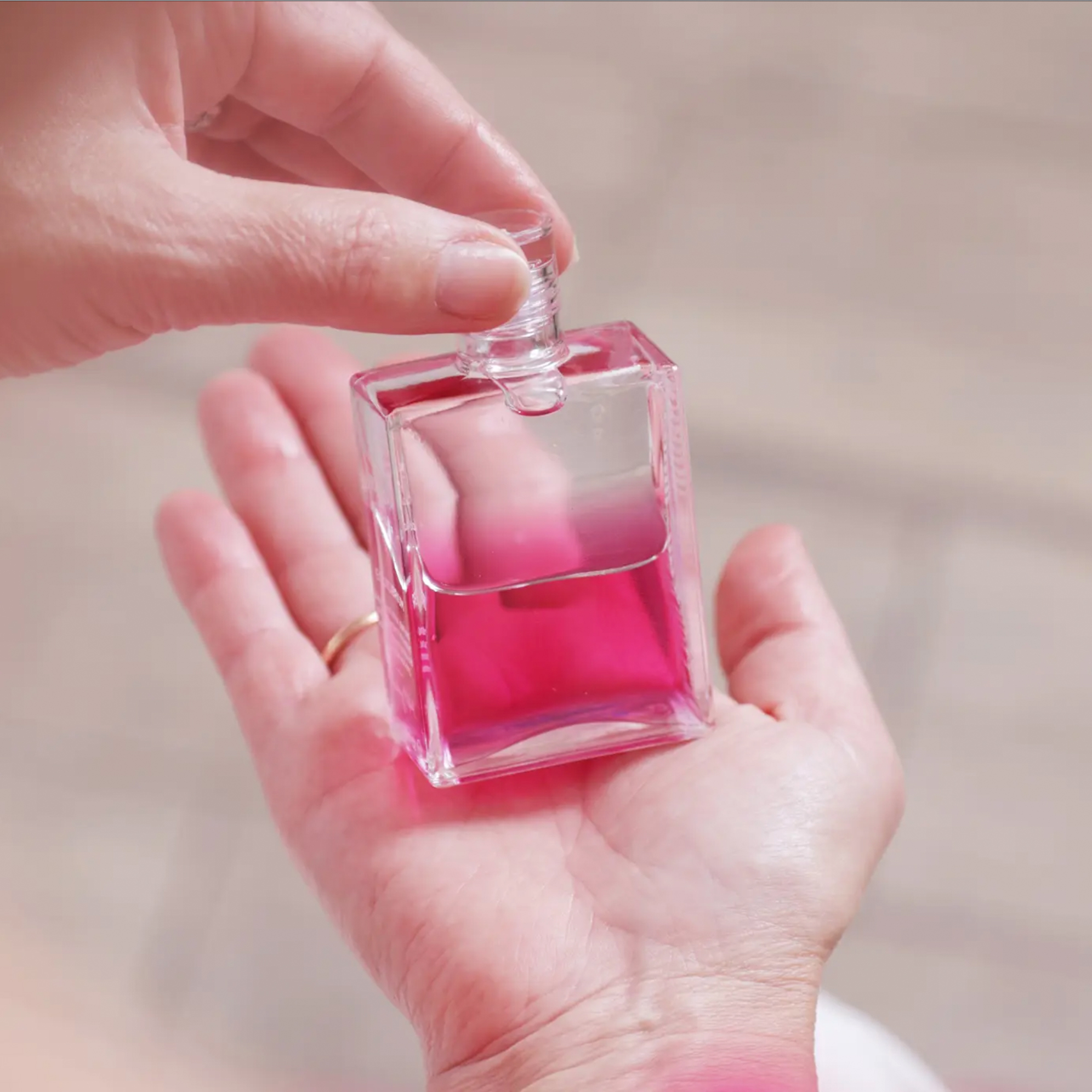 Aura-Soma Equilibrium B77 Die Aura-Soma Equilibriumflasche B77 wird auf einer Hand gehalten.